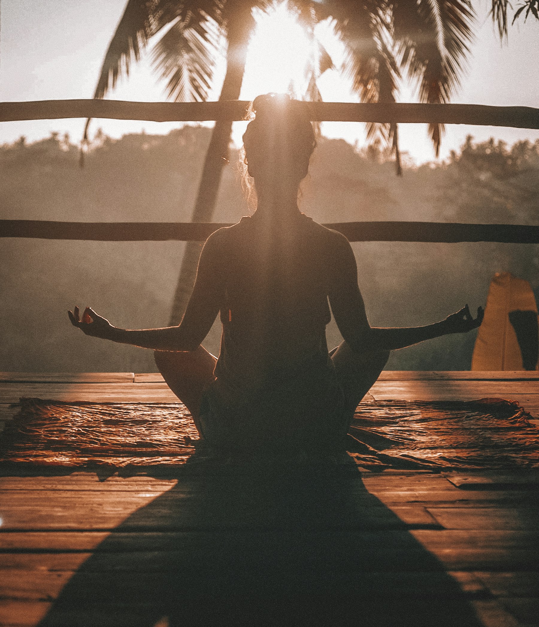 Vrouw in een rustige yogahouding bij zacht ochtendlicht